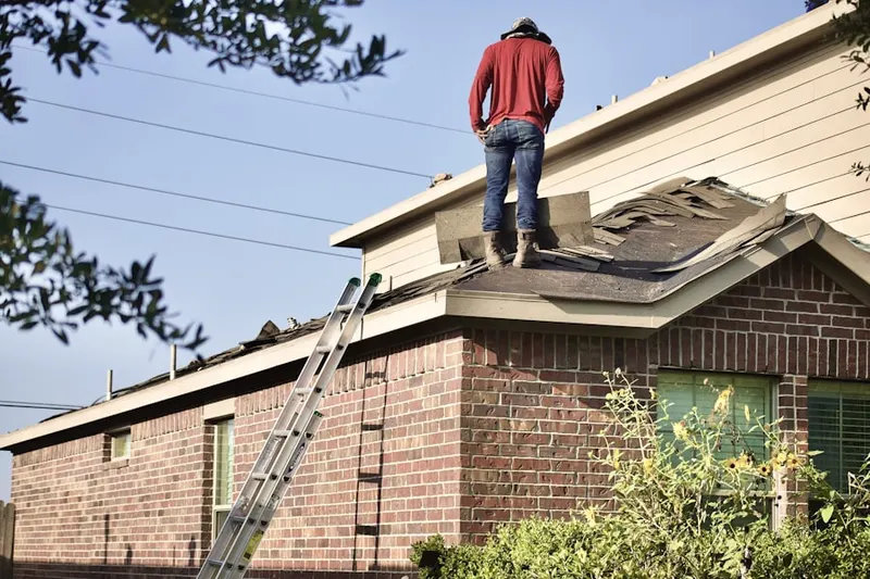Professional roofer working on a residential roof in Atmore